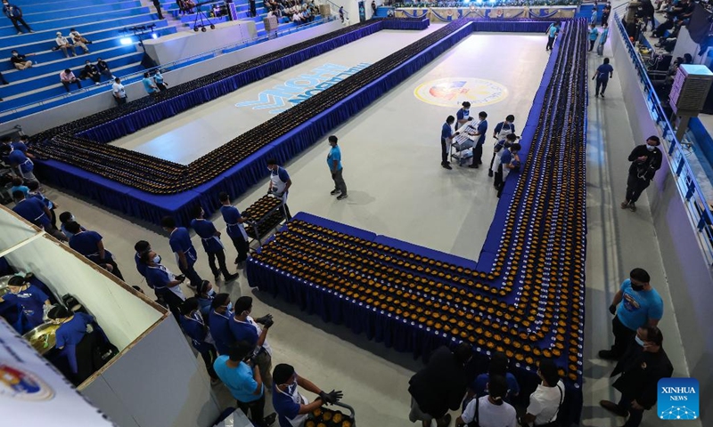 Volunteers arrange the noodle bowls during Malabon City's attempt to break the Guinness World Record for the longest line of bowls of noodles in Malabon City, the Philippines, on March 21, 2025. The city successfully achieved the Guinness World Record for the longest line of bowls of noodles with 6,549 bowls. Photo: Xinhua