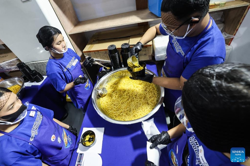 Volunteers prepare the noodle bowls during Malabon City's attempt to break the Guinness World Record for the longest line of bowls of noodles in Malabon City, the Philippines, on March 21, 2025. The city successfully achieved the Guinness World Record for the longest line of bowls of noodles with 6,549 bowls. Photo: Xinhua