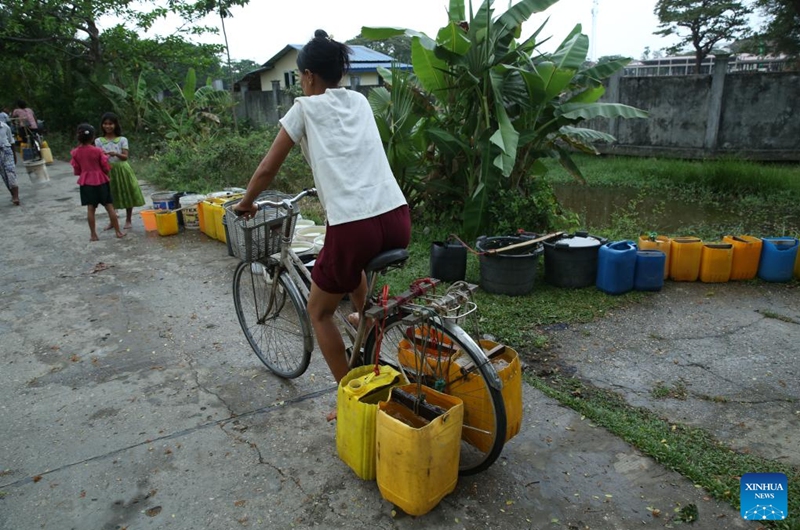 A woman carries water by bike at Dala Township on the outskirts of Yangon, Myanmar, March 22, 2025. World Water Day is observed around the world on March 22 every year. Photo: Xinhua