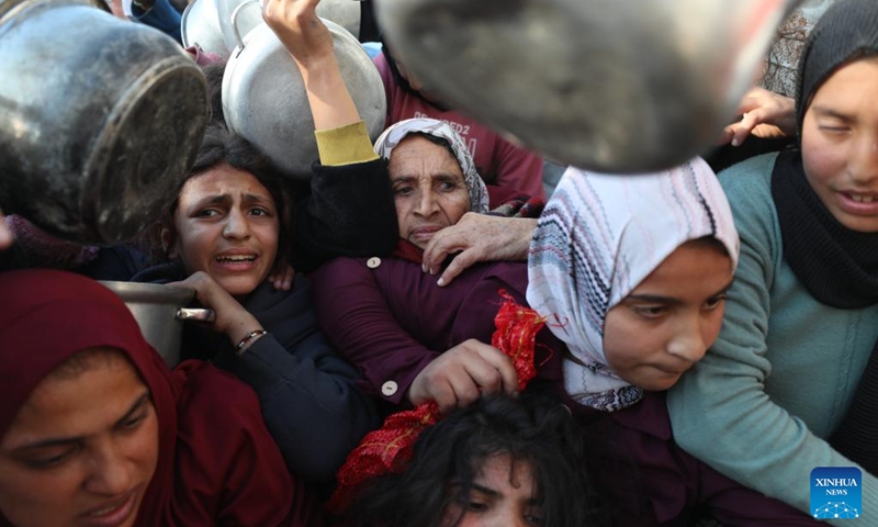 Palestinians wait to receive free food from a food distribution center in Beit Lahia, northern Gaza Strip, on March 22, 2025. Photo: Xinhua