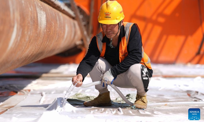 A man works at the construction site of Taoyaomen highway-railway bridge in east China's Zhejiang Province, March 22, 2025. The second layer of concrete pouring for the foundation cap of Pier 5 of the bridge, a crucial cross-sea passage connecting Cezi Island and Fuchi Island of the Zhoushan Islands, was completed on Saturday, marking the transition of the bridge construction into the main tower phase. The 1,531-meter-long bridge, with a main span of 666 meters, serves as a key project of the Ningbo-Zhoushan Railway. Photo: Xinhua