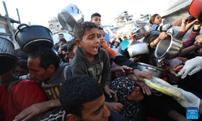 Palestinians wait to receive free food from a food distribution center in Beit Lahia, northern Gaza Strip, on March 22, 2025. Photo: Xinhua
