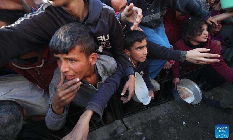 Palestinians wait to receive free food from a food distribution center in Beit Lahia, northern Gaza Strip, on March 22, 2025. Photo: Xinhua