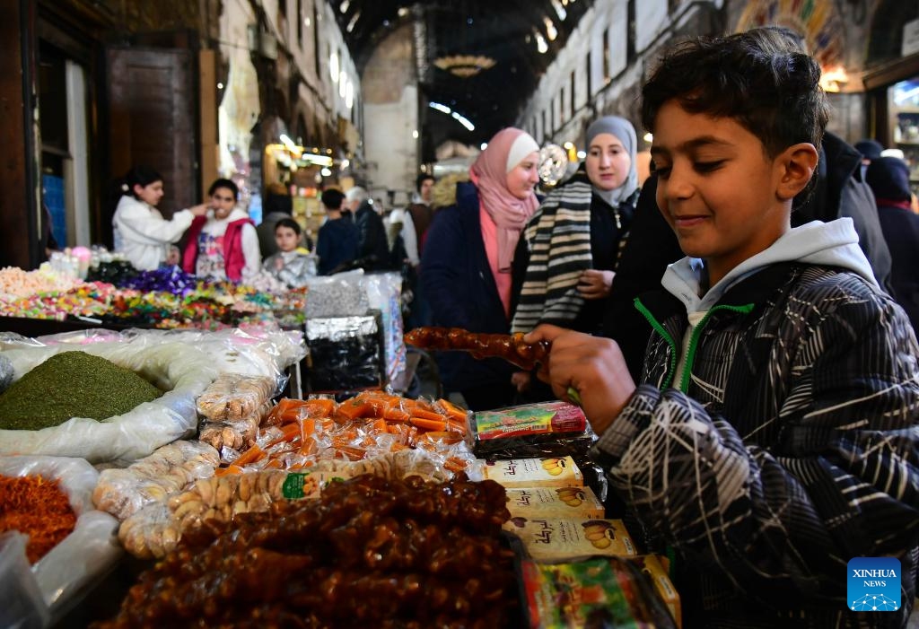Shoppers purchase colorful sweets and traditional goods in historic al-Buzuriyah market in Damascus, Syria, on March 23, 2025.(Photo: Xinhua)