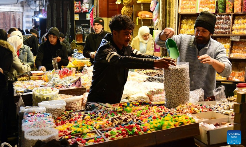 Shoppers purchase colorful sweets and traditional goods in historic al-Buzuriyah market in Damascus, Syria, on March 23, 2025.(Photo: Xinhua)