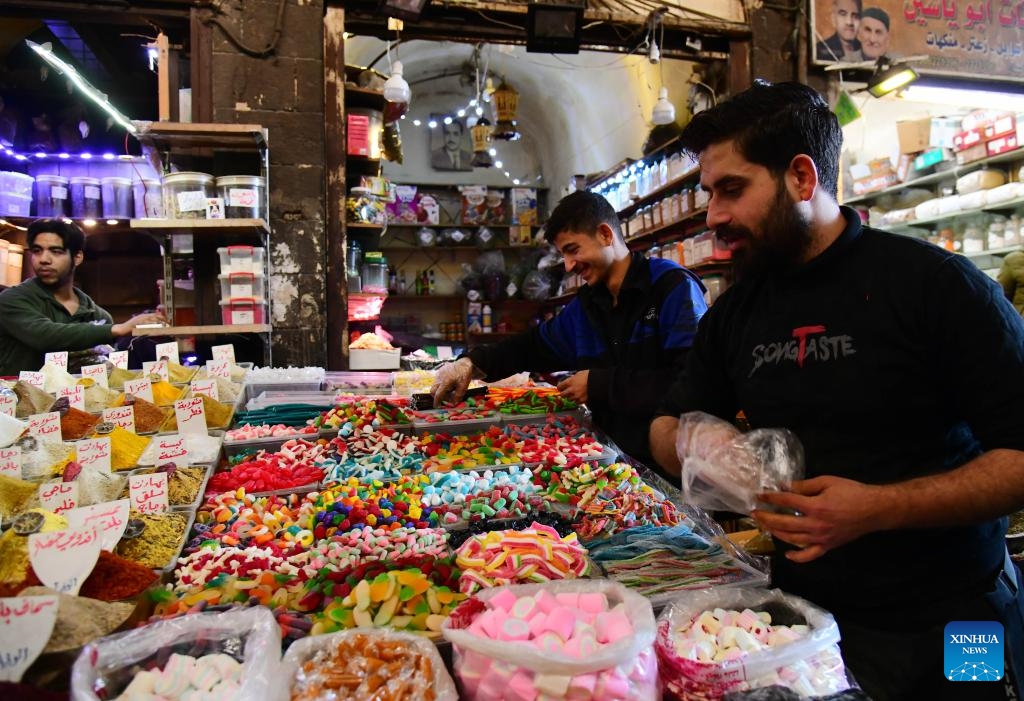 Shoppers purchase colorful sweets and traditional goods in historic al-Buzuriyah market in Damascus, Syria, on March 23, 2025.(Photo: Xinhua)