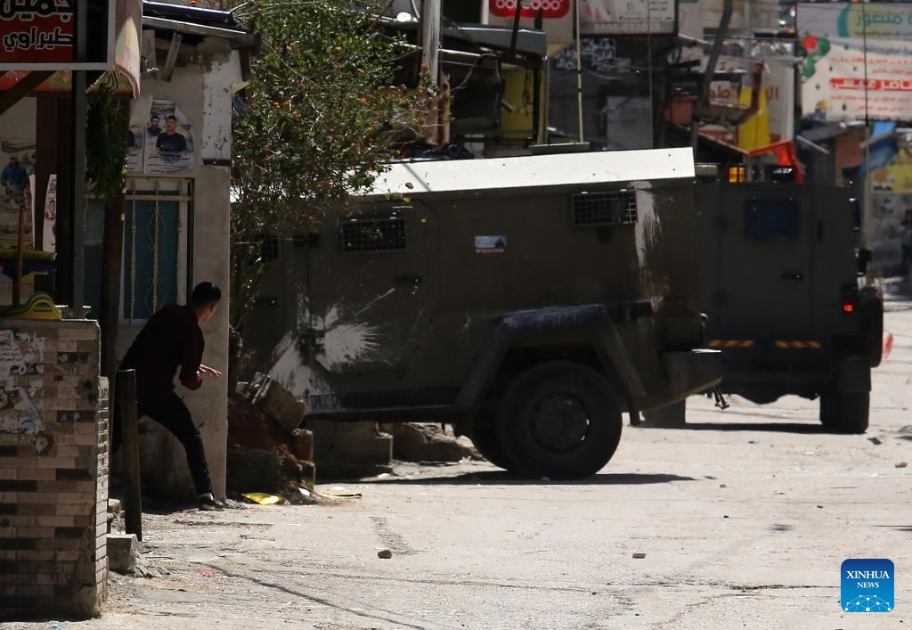A Palestinian takes cover during clashes with Israeli forces in the Balata refugee camp, east of Nablus in the northern West Bank, on March 24, 2025. (Photo: Xinhua)