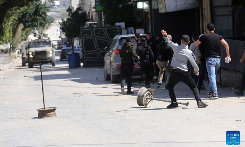 Palestinians confront Israeli forces during clashes in the Balata refugee camp, east of Nablus in the northern West Bank, on March 24, 2025. (Photo: Xinhua)