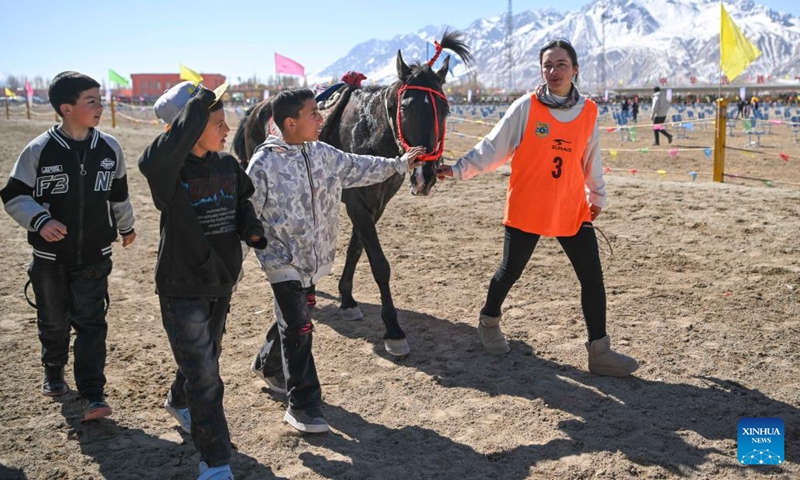 Gulayisa Dihan (R) walks around the field with three boys after the 5,000-meter speed horse race during the Spring Tourism Series Activities in Taxkorgan Tajik Autonomous County, northwest China's Xinjiang Uygur Autonomous Region, March 23, 2025. Let's applaud the county's first-ever female rider! The announcer cheered as 22-year-old Gulayisa Dihan crossed the finish line of the 5,000-meter speed horse race third in her group. (Photo: Xinhua)
