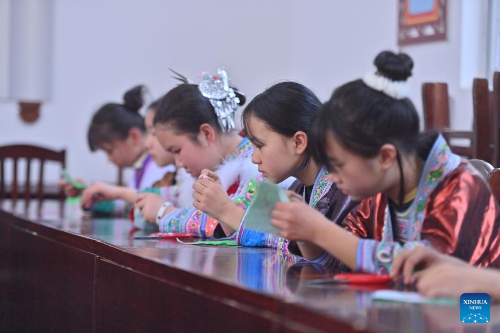 Students experience embroidery at a primary school in Rongshui Miao Autonomous County of Liuzhou City, south China's Guangxi Zhuang Autonomous Region, March 25, 2025. Students of various ethnic groups at a primary school in Rongshui held a celebration prior to the Sanyuesan Festival, a festival celebrated on the third day of the third lunar month, by wearing traditional costumes and staging traditional performances on Tuesday. This year's Sanyuesan Festival falls on March 31. (Photo: Xinhua)
