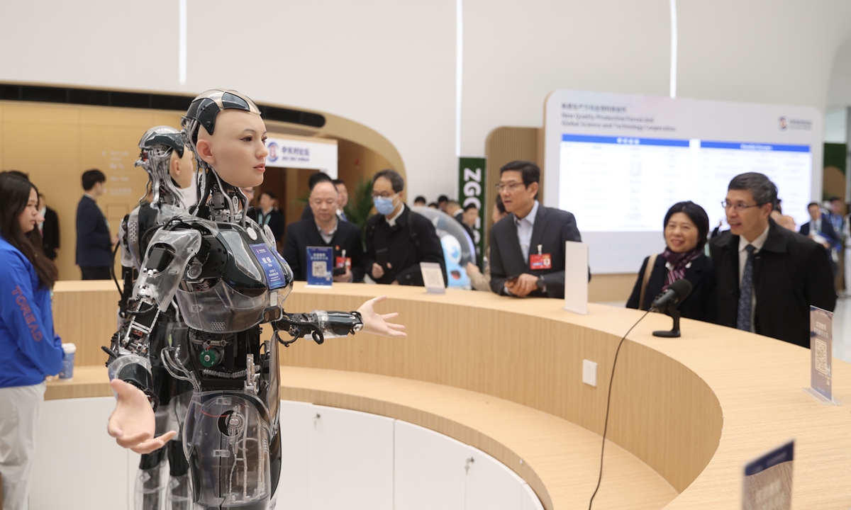 Guests interact with robot receptionists at the 2025 Zhongguancun Forum Annual Conference in Beijing on March 27, 2025. Photo: VCG