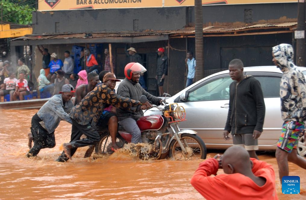 People wade through a flooded road in Kampala, capital city of Uganda, March 26, 2025. Heavy downpour and floods hit Kampala recently. (Photo: Xinhua)