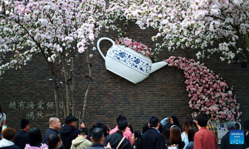 People admire crabapple blossoms at the Wudadao historical urban area in north China's Tianjin, April 3, 2025. The third edition of a crabapple blossom festival kicked off on Thursday at Wudadao historical urban area, a popular tourist destination in the downtown area of Tianjin. The festival, which stays on until April 13, features more than 100 art and culture performances to enable 