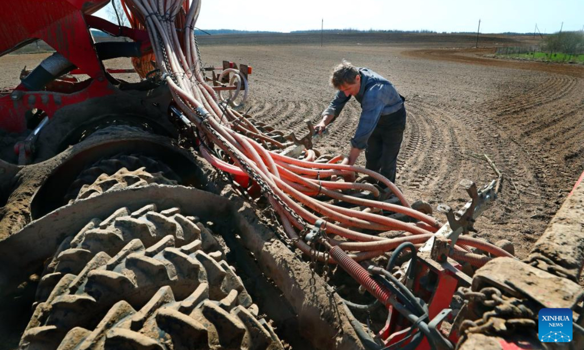 A farmer checks a farm machine in a field in Minsk region, Belarus, April 18, 2025. (Photo: Xinhua)