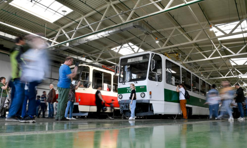 People look at trams at a depot in Moscow, Russia, on April 19, 2025. A parade of retro tramways was held on Saturday to mark the 126th anniversary of the opening of the first tram line in Moscow. (Photo by Alexander Zemlianichenko Jr/Xinhua)