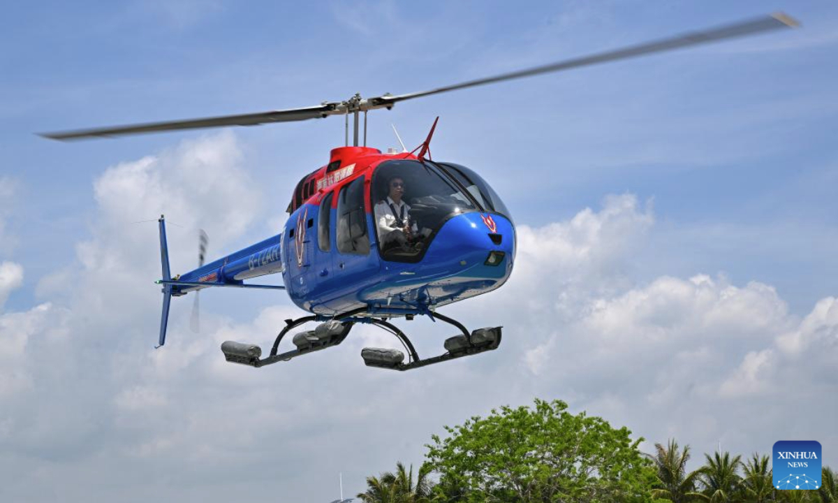 Tourists enjoy a helicopter sightseeing tour in Sanya, south China's Hainan Province, May 3, 2025. Low-altitude tourism activities such as paragliding and parachuting have become trendy among tourists to China's island province of Hainan during the May Day holiday. (Xinhua/Guo Cheng)