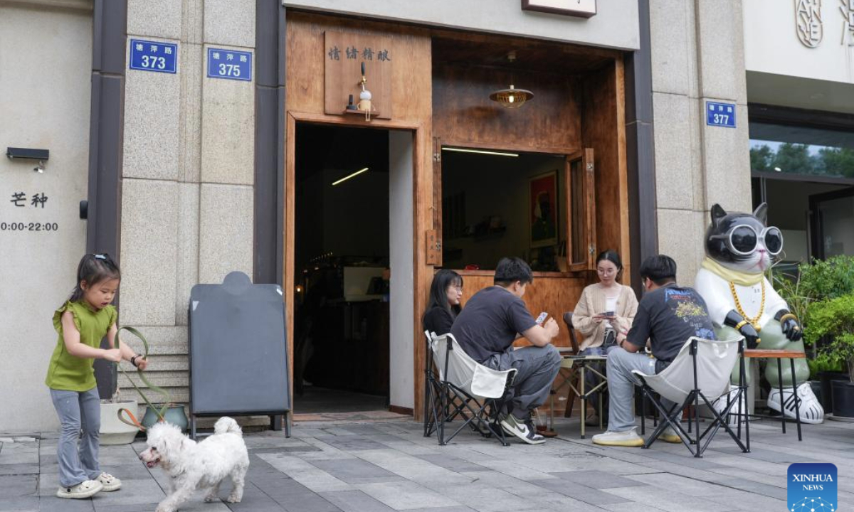 People enjoy their leisure time in front of a cafe in Hangzhou, east China's Zhejiang Province, May 4, 2025. People across China enjoy the ongoing May Day holiday in various ways. (Xinhua/Huang Zongzhi)