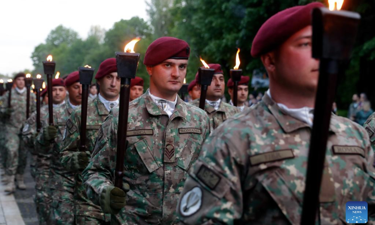 Soldiers carry torches during a march to commemorate the Romanian Land Forces Day in Bucharest, Romania, April 27, 2025. (Photo by Cristian Cristel/Xinhua)