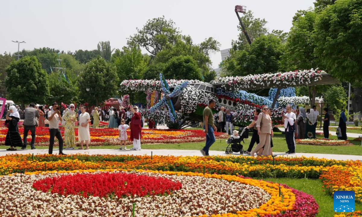People enjoy floral displays at the square of the National Library of Uzbekistan in Tashkent, Uzbekistan, May 1, 2025. A flower festival is held in Tashkent on Thursday, attracting many local visitors. (Photo by Zafar Khalilov/Xinhua)
