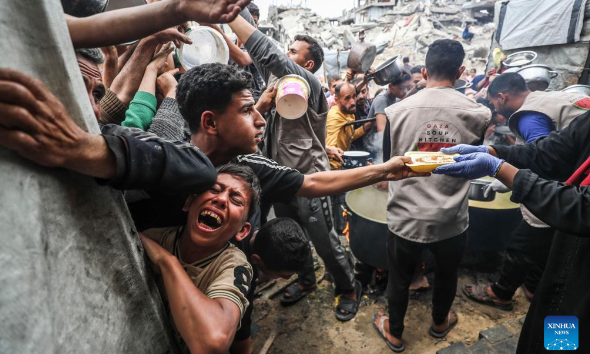 Palestinians wait to receive free food from a food distribution center in Gaza City, on April 24, 2025. As regional and international mediation intensifies to reach a lasting ceasefire in the Gaza Strip, many Palestinians are expressing cautious hope that current diplomatic efforts will result in sustainable peace and relief for their war-affected communities. (Photo: Xinhua)