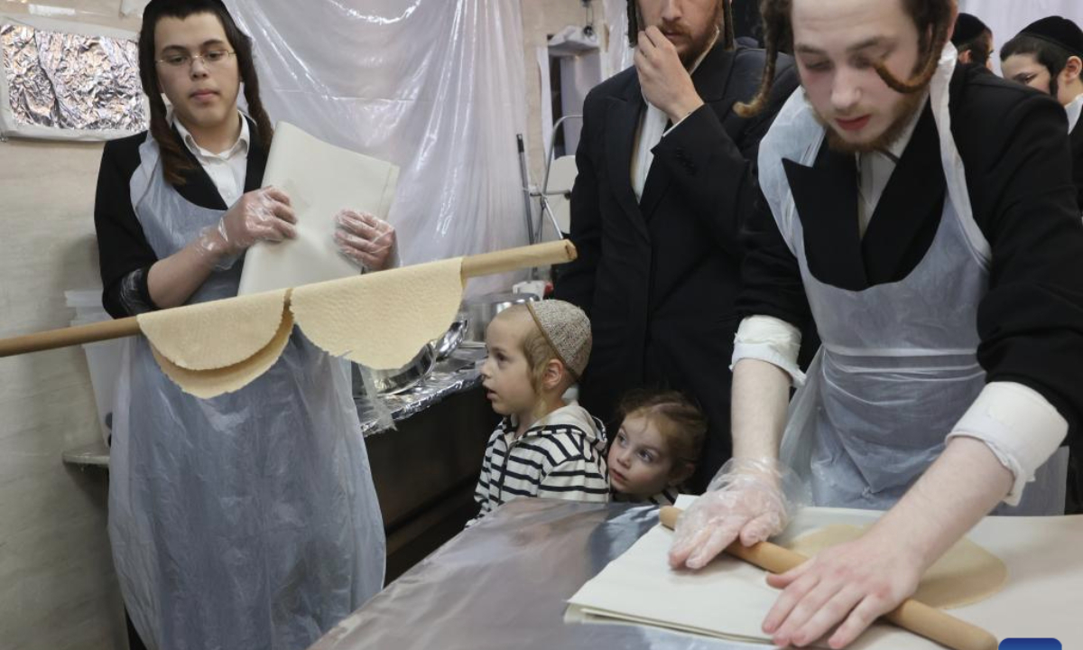 Ultra-Orthodox Jewish men prepare matza, a traditional unleavened bread, for the upcoming Jewish holiday of Passover at a bakery in central Israeli city of Rehovot, on March 30, 2025. (Photo by Gil Cohen Magen/Xinhua)