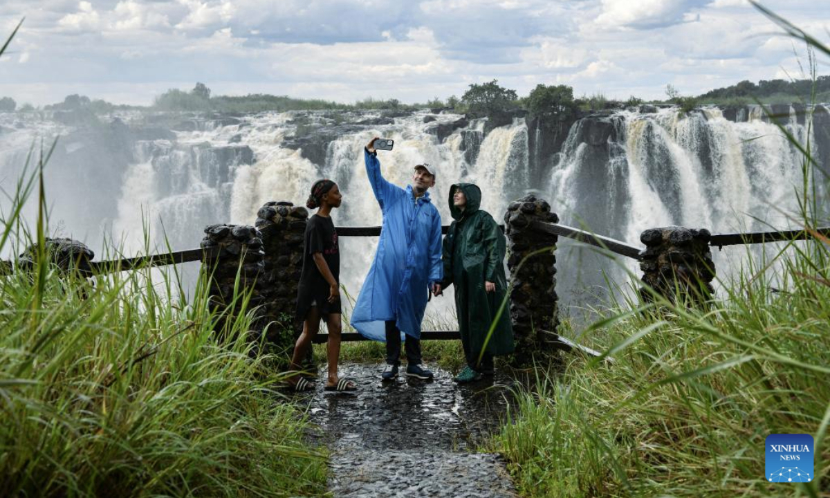 Tourists enjoy the scenery of Victoria Falls in Zambia on March 29, 2025. (Xinhua/Han Xu)
