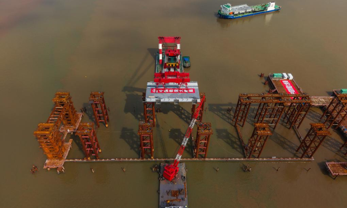 An aerial drone photo taken on April 29, 2025 shows the setting scene of the first steel box girder of Wanlong Grand Bridge in Nansha District of Guangzhou, south China's Guangdong Province. The first steel box girder of Wanlong Grand Bridge, with a length of 5,146 meters, a main bridge of 1,150 meters and a main span of 608 meters, was successfully set on Tuesday. The bridge, located at Guangdong-Hong Kong-Macao Greater Bay Area, is the world's largest-span self-anchored suspension bridge. Photo:Xinhua
