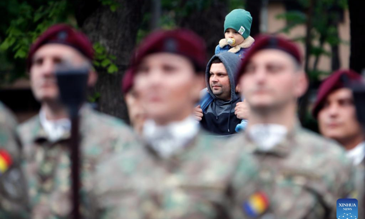 A child gazes at soldiers before a march to commemorate the Romanian Land Forces Day in Bucharest, Romania, April 27, 2025. (Photo by Cristian Cristel/Xinhua)