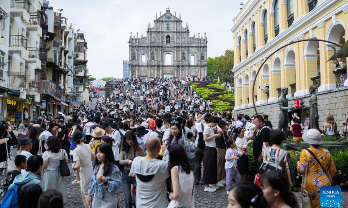 Tourists are pictured near the Ruins of St. Paul's in south China's Macao, May 3, 2025. The first three days of China's May Day holiday saw a significant influx of visitors to the Macao Special Administrative Region (SAR), injecting new vitality into the local tourism industry. Statistics from the SAR's Public Security Police Force (CPSP) showed that from Thursday to Saturday, Macao's border checkpoints recorded entries and exits of 731,474, 837,062, and 826,273, respectively. Friday experienced the highest daily total, including 221,968 incoming visitors, marking the highest single-day record for inbound tourists since the pandemic.(Xinhua/Cheong Kam Ka)