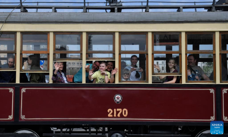 Passengers on a tram greet spectators during a parade of retro tramways in Moscow, Russia, on April 19, 2025. A parade of retro tramways was held on Saturday to mark the 126th anniversary of the opening of the first tram line in Moscow. (Photo by Alexander Zemlianichenko Jr/Xinhua)