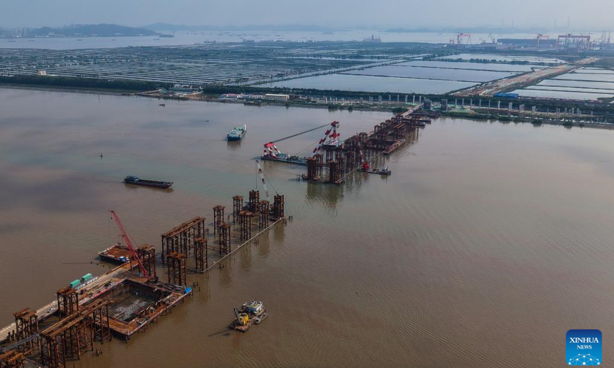 An aerial drone photo taken on April 29, 2025 shows the setting scene of the first steel box girder of Wanlong Grand Bridge in Nansha District of Guangzhou, south China's Guangdong Province. The first steel box girder of Wanlong Grand Bridge, with a length of 5,146 meters, a main bridge of 1,150 meters and a main span of 608 meters, was successfully set on Tuesday. The bridge, located at Guangdong-Hong Kong-Macao Greater Bay Area, is the world's largest-span self-anchored suspension bridge. Photo:Xinhua