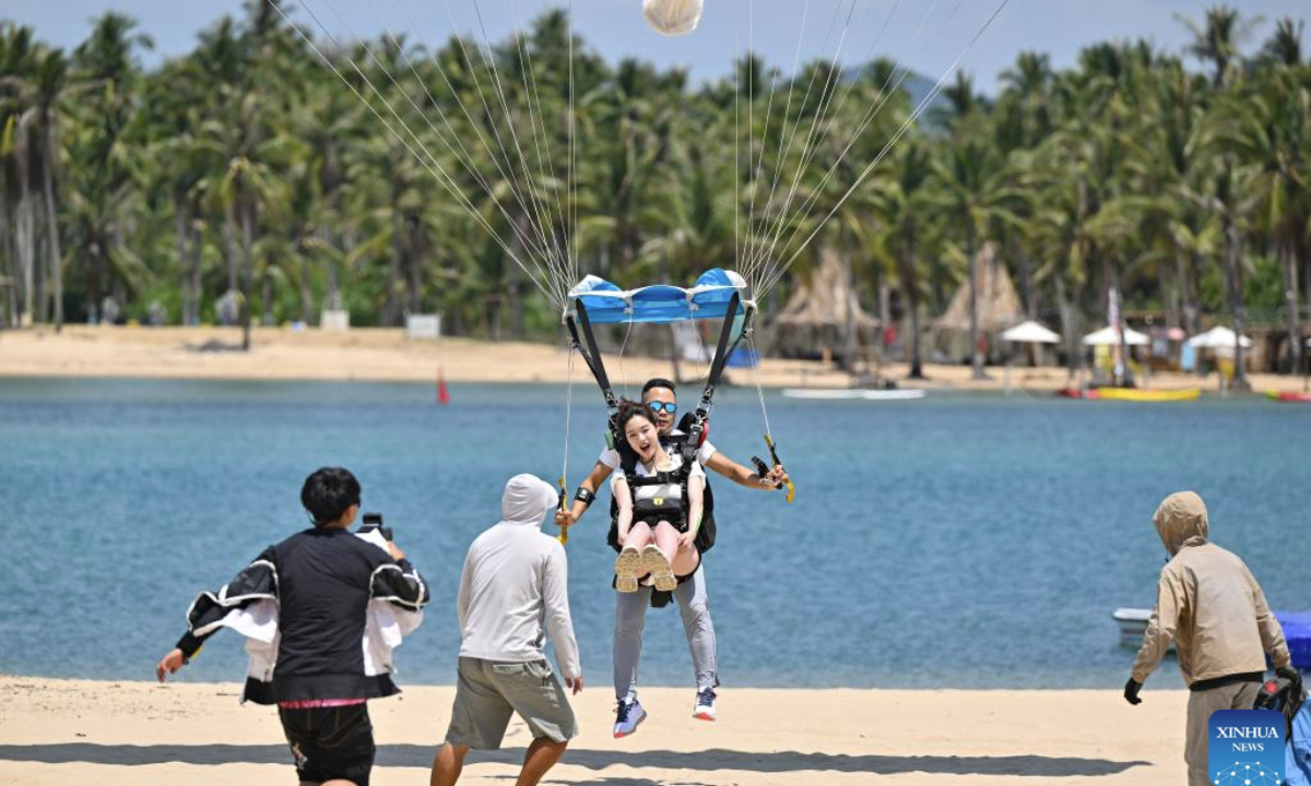 A tourist tries parachuting in Sanya, south China's Hainan Province, May 2, 2025. Low-altitude tourism activities such as paragliding and parachuting have become trendy among tourists to China's island province of Hainan during the May Day holiday. (Xinhua/Guo Cheng)
