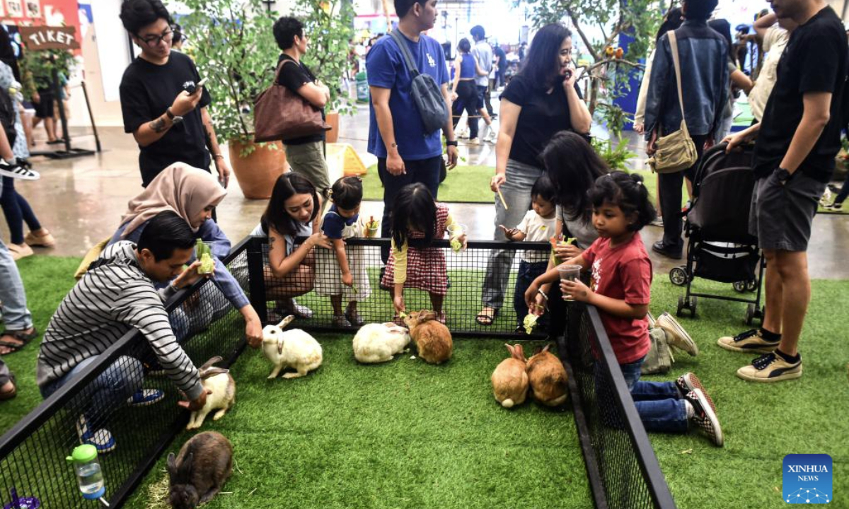 People feed rabbits during Pet Fest 2025 in Tangerang, Banten, Indonesia, May 4, 2025. The event is being held here from May 2 to May 4, featuring various activities including pet lover community sessions and pet product displays. (Xinhua/Agung Kuncahya B.)