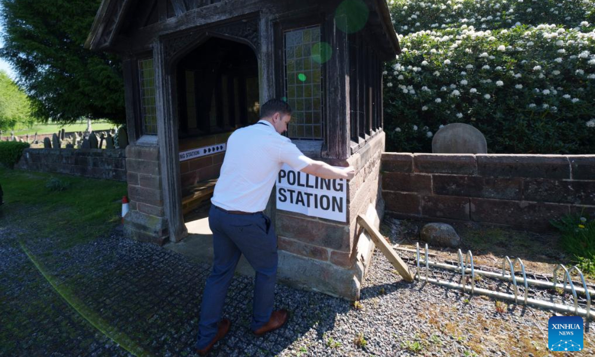 A staff member places a sign outside a polling station in Daresbury, Cheshire, Britain, May 1, 2025. Voters across England went to the polls on Thursday for local elections in the first major electoral test for political parties since the general election last year. More than 1,600 seats are being contested in councils across England. The elections also cover six mayoralties and a by-election in Runcorn and Helsby in Cheshire, the first since last year's general election. (Photo by Jon Super/Xinhua)