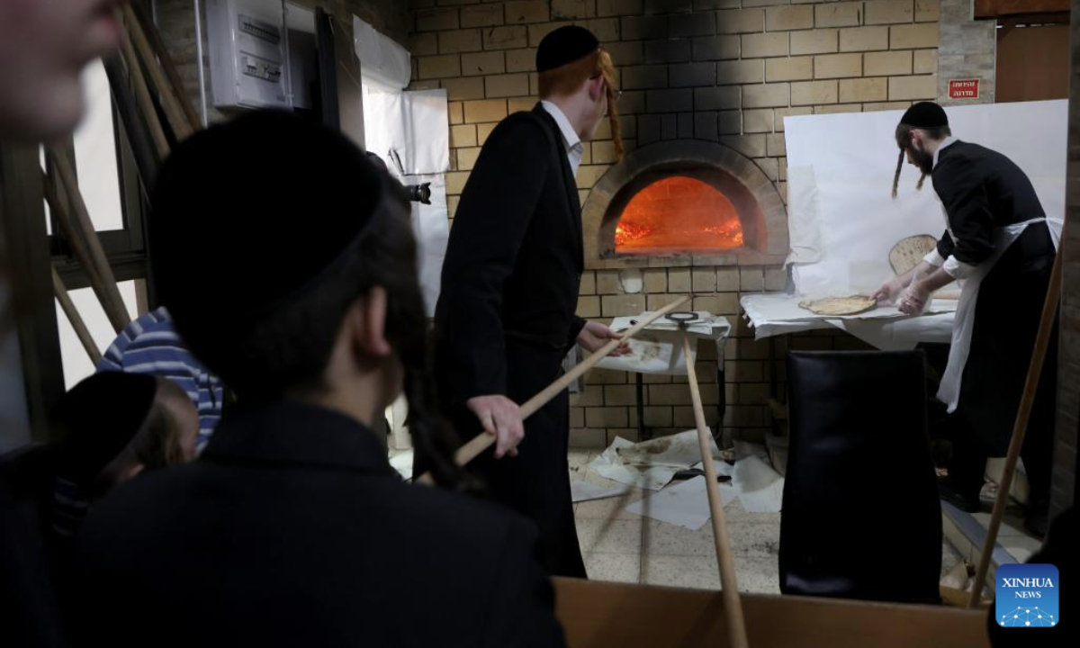 Ultra-Orthodox Jewish men prepare matza, a traditional unleavened bread, for the upcoming Jewish holiday of Passover at a bakery in central Israeli city of Rehovot, on March 30, 2025. (Photo by Gil Cohen Magen/Xinhua)