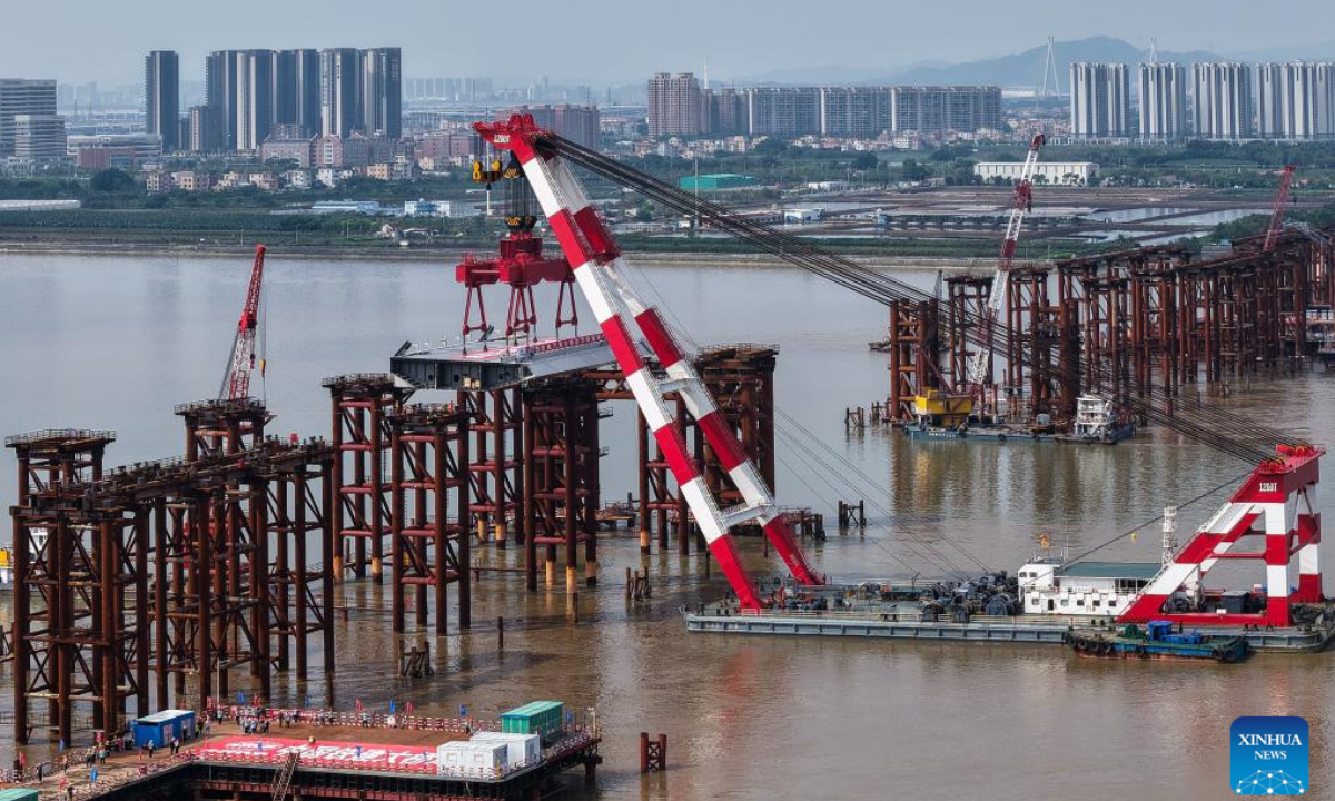 An aerial drone photo taken on April 29, 2025 shows the setting scene of the first steel box girder of Wanlong Grand Bridge in Nansha District of Guangzhou, south China's Guangdong Province. The first steel box girder of Wanlong Grand Bridge, with a length of 5,146 meters, a main bridge of 1,150 meters and a main span of 608 meters, was successfully set on Tuesday. The bridge, located at Guangdong-Hong Kong-Macao Greater Bay Area, is the world's largest-span self-anchored suspension bridge. Photo:Xinhua