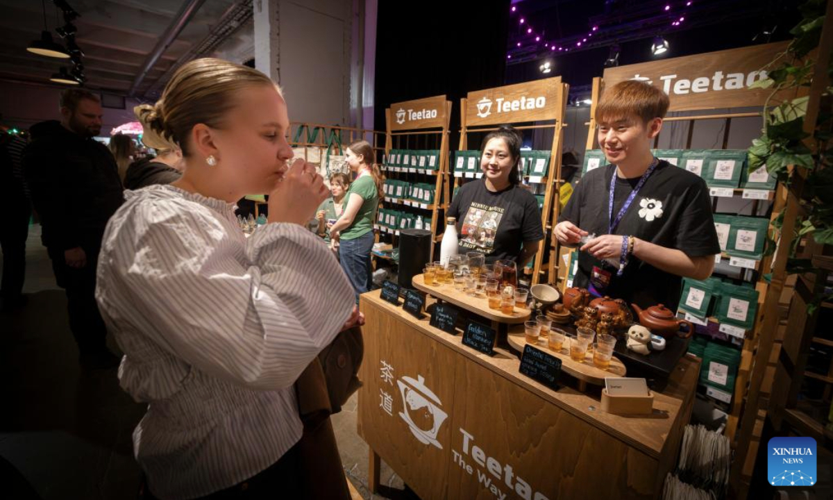 A woman tastes tea beverages displayed by a Chinese exhibitor during the 2025 Helsinki Coffee Festival in Helsinki, Finland, April 26, 2025. The 2025 Helsinki Coffee Festival is held here from April 25 to 27, featuring about 60 exhibitors showcasing their coffee products, tea beverages, coffee appliances and a variety of products. (Photo by Matti Matikainen/Xinhua)