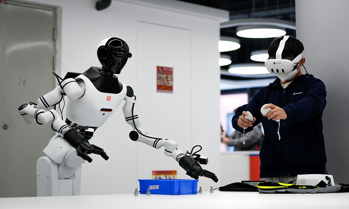 A worker trains a humanoid industrial robot at the humanoid robot data training center in Shougang Park in Beijing on March 27, 2025. China has become a key player in the global humanoid robot industry, with its market projected to be worth 6 trillion yuan ($836.87 billion) by 2050, per Xinhua. Photo: VCG