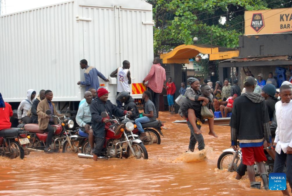 People wade through a flooded road in Kampala, capital city of Uganda, March 26, 2025. Heavy downpour and floods hit Kampala recently. (Photo: Xinhua)