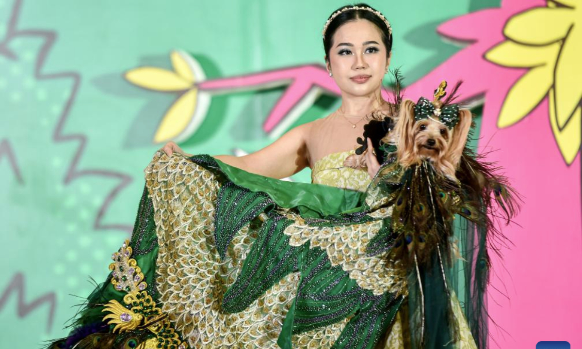 A woman and her dog participate in a fashion show for dogs and cats during Pet Fest 2025 in Tangerang, Banten, Indonesia, May 4, 2025. The event is being held here from May 2 to May 4, featuring various activities including pet lover community sessions and pet product displays. (Xinhua/Agung Kuncahya B.)