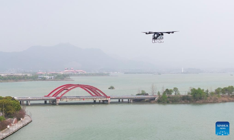 A drone photo taken on March 27, 2025 shows the air module of XPENG's flying car AEROHT conducting a flight demonstration at Liuye Lake Tourist Resort in Changde City, central China's Hunan Province. A ceremony for the flying car's maiden flight in Hunan was held by Chinese electric vehicle maker XPENG here on Thursday. The flying car consisting of a ground module, an electric vehicle, and an air module, performed the application scenario of cross-water flight on the day. (Photo: Xinhua)