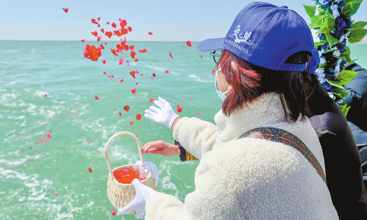 A woman spreads flowers as part of the Beijing-Tianjin-Hebei sea burial sailing event jointly sponsored by the civil affairs departments of Beijing, Tianjin and Hebei Province in the Bohai Bay on March 30, 2025. The event was held before the upcoming Qingming Festival, or Tomb-Sweeping Day, that falls on April 4 this year. Photo: VCG