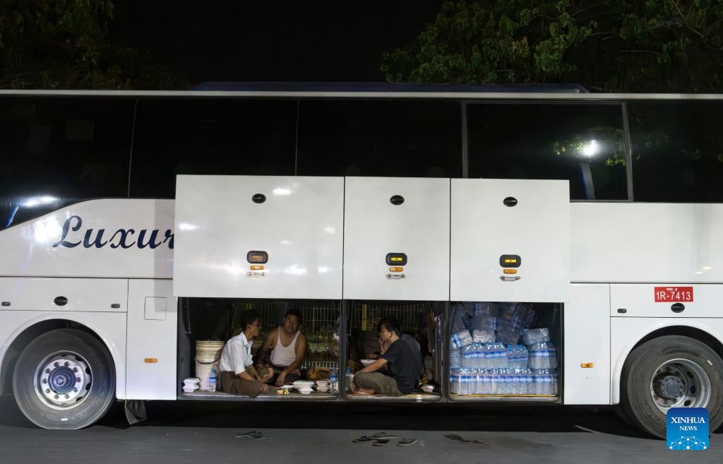 People rest in the luggage cabin of a bus in Mandalay, Myanmar, March 31, 2025. The weather in Mandalay is hot recently, and the temperature can reach 40 degrees Celsius during the day. (Photo: Xinhua)