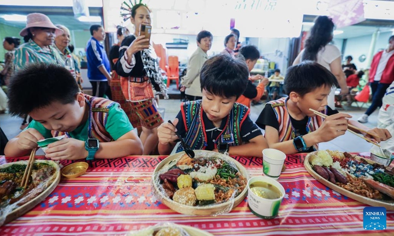 Tourists enjoy a feast during a Sanyuesan celebration in Wuzhishan City of south China's Hainan Province, March 30, 2025. Local people held various events in Wuzhishan to celebrate the Sanyuesan Festival which falls on the third day of the third lunar month. (Photo: Xinhua)