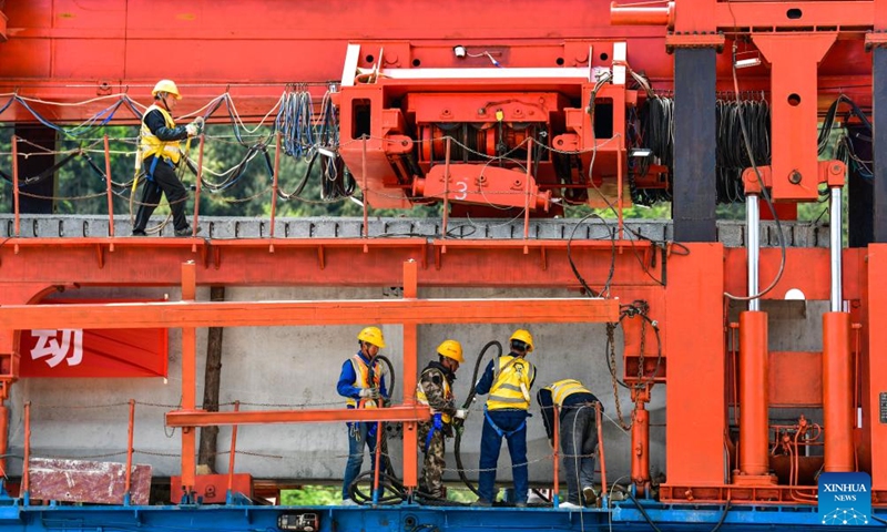 Workers install a T-beam at the construction site of Jiangjiaping bridge of the extension project of Weng'an-Machangping Railway in southwest China's Guizhou Province, March 31, 2025. The prefabricated T-beam and track laying of the 148-kilometer-long extension project of Weng'an-Machangping Railway was launched on Monday. (Photo: Xinhua)