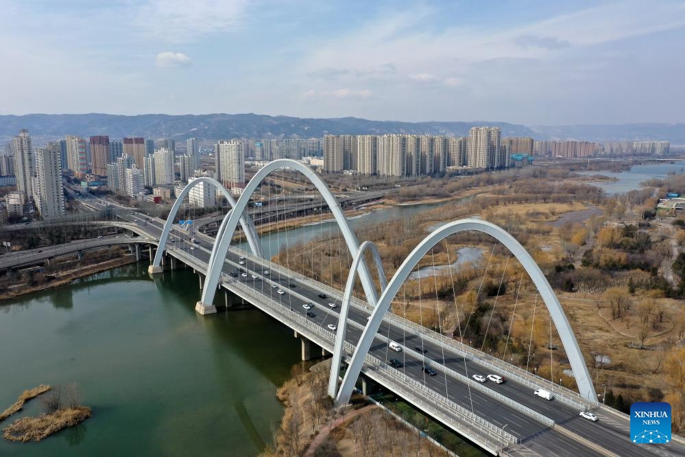 An aerial drone photo taken on Feb. 20, 2025 shows cars running on a bridge in Taiyuan City, north China's Shanxi Province. Taiyuan, with a history of over 2,500 years, is a renowned historical and cultural city in northern China. In recent years, the city has coordinated efforts to upgrade industrial structure, protect the environment and improve urban management, achieving coordinated progress in environmental restoration, economic development and people's livelihoods. (Photo: Xinhua)