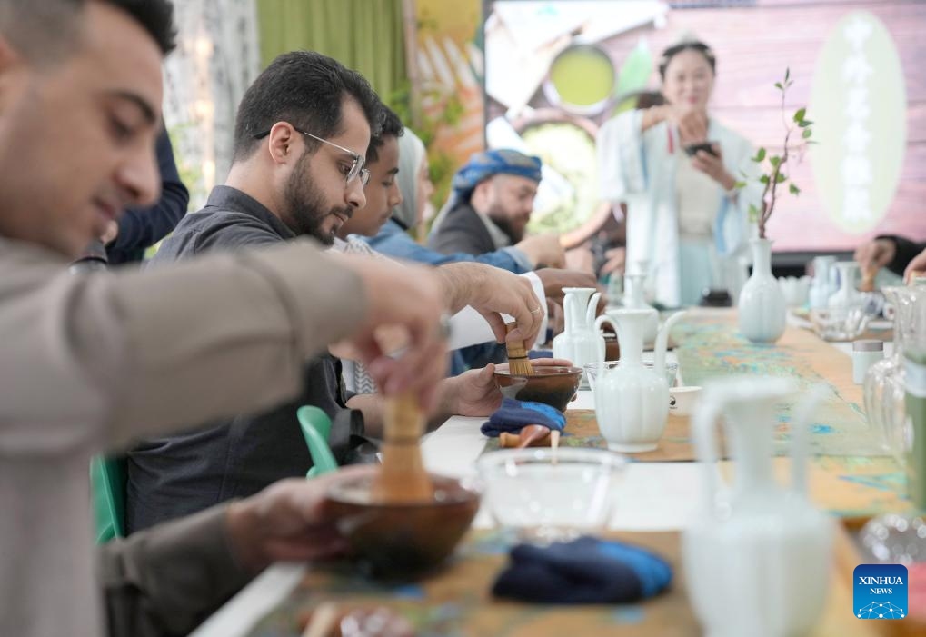 Foreign residents learn tea art under the guidance of an artisan at Jimingshan Community in Yiwu, east China's Zhejiang Province, April 3, 2025. A cultural activity for Chinese and foreign residents was held here on Thursday. (Photo: Xinhua)