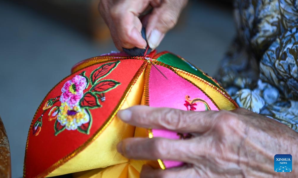 A villager makes an embroidered ball in Jiuzhou Village of Jingxi City, south China's Guangxi Zhuang Autonomous Region, April 2, 2024. Guangxi Zhuang Autonomous Region is the autonomous region with the largest population of ethnic minorities in China, with multiple ethnic groups such as Zhuang, Yao, Miao, and Dong who have lived there for generations. Throwing embroidered balls is a traditional sport that Guangxi people enjoy, carrying a profound folk heritage. In Zhuang culture, embroidered ball is a symbol of love. (Photo: Xinhua)


