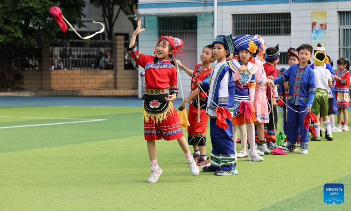 A student throws the embroidered ball at Minzu Road East Primary School in Nanning, south China's Guangxi Zhuang Autonomous Region, Nov 6, 2024. Guangxi Zhuang Autonomous Region is the autonomous region with the largest population of ethnic minorities in China, with multiple ethnic groups such as Zhuang, Yao, Miao, and Dong who have lived there for generations. Throwing embroidered balls is a traditional sport that Guangxi people enjoy, carrying a profound folk heritage. In Zhuang culture, embroidered ball is a symbol of love. (Photo: Xinhua)

