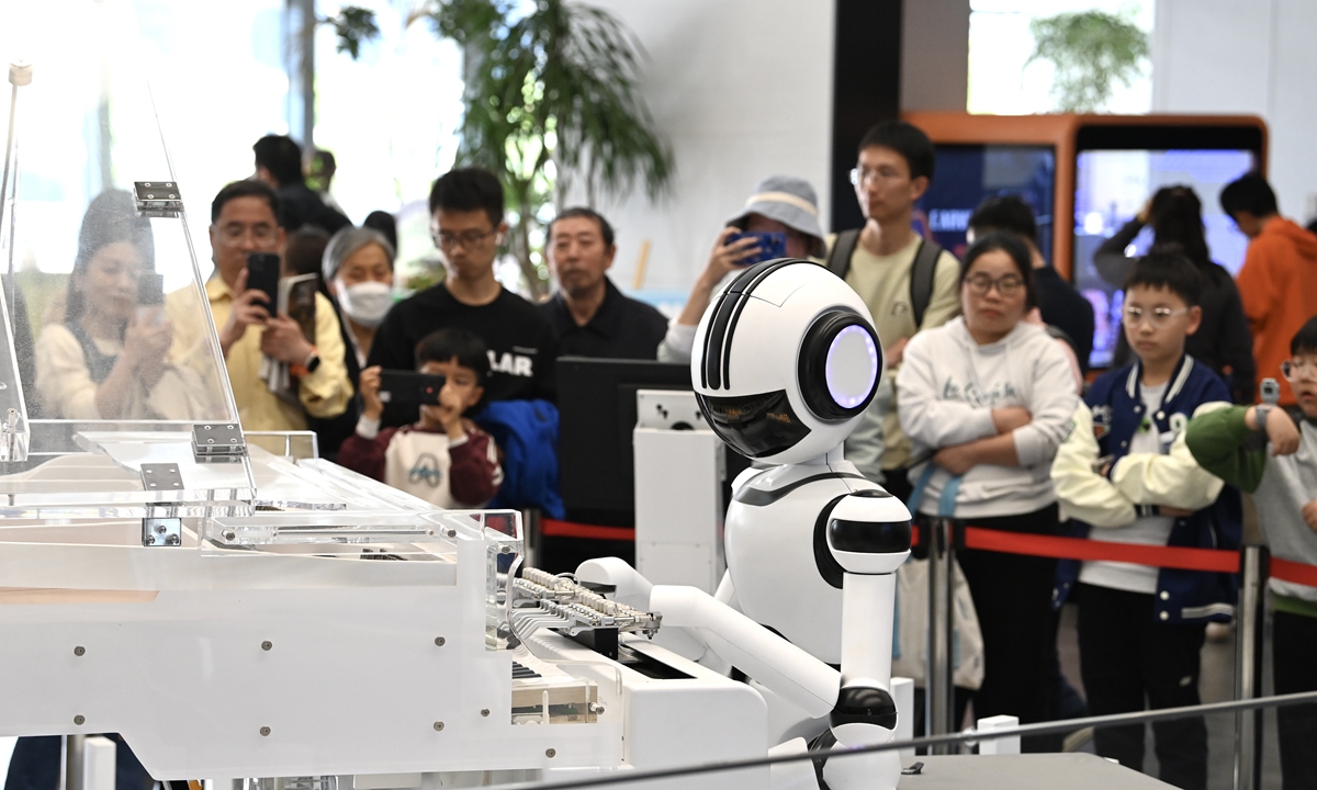 A humanoid robot plays a piano while children and parents look on inside a library in Hefei, East China's Anhui Province on April 6, 2025. By mid-century, China's humanoid robot market could be worth 6 trillion yuan ($825.53 billion), with an estimated 59 million units in operation, according to Xinhua. Photo: cnsphoto